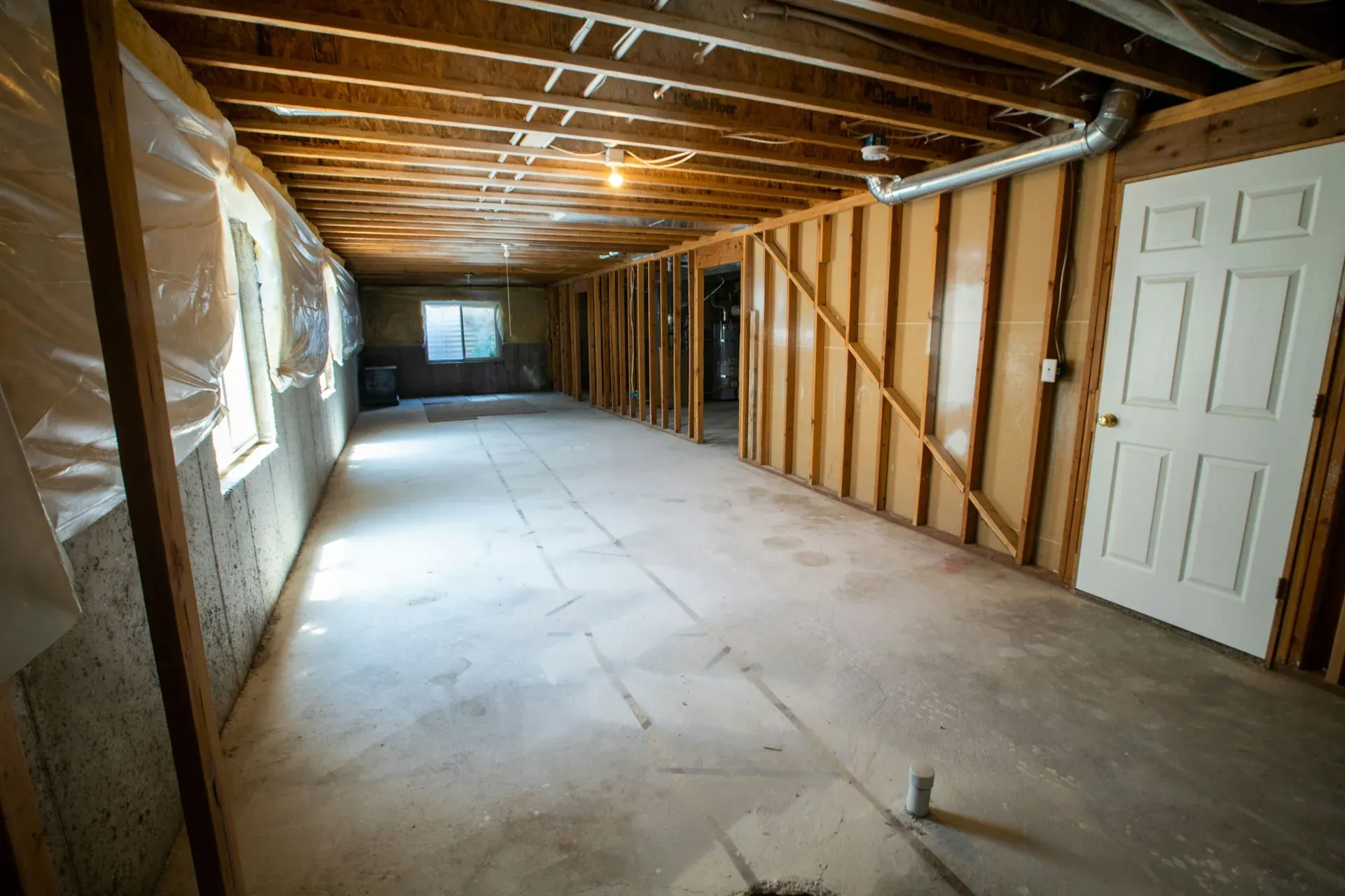 Open, unfinished basement framed and ready for drywall